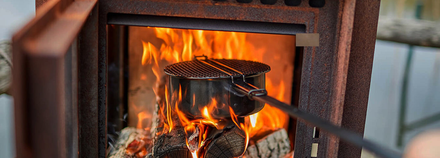 Cooking outdoors in the highlands of Scotland. The rb73 Quercus is ideal for this.The Quercus is an outdoor fireplace with 3-sided glass and an oven. The visible parts are made of 6 mm CorTen steel